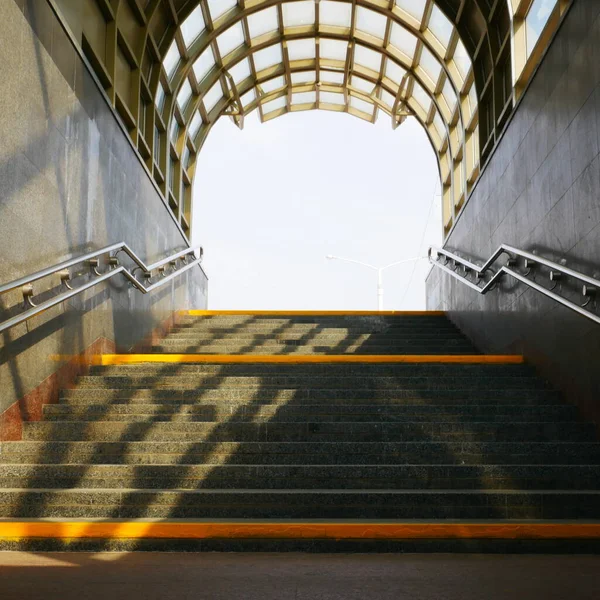 subway staircase with railings and yellow steps