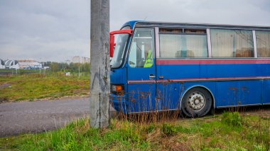 Uzun mavi otobüs yolda duruyor.