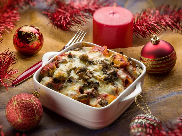 Forno pasta sopra la tavola di Natale rosso — Foto Stock