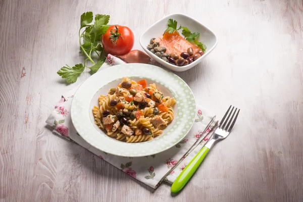 Pasta with fresh salmon tomatoes capers and olives — Stock Photo, Image