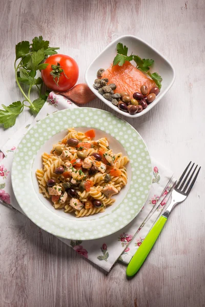 Pasta with fresh salmon tomatoes capers and olives — Stock Photo, Image