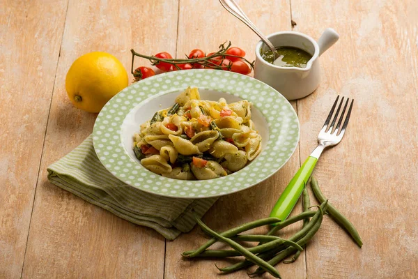 Pasta with pesto sauce green peas and fresh tomatoes — Stock Photo, Image