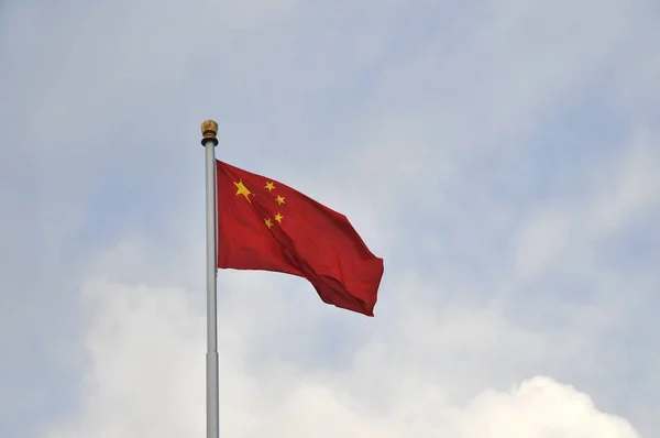 Красный с пятью жёлтыми звездами китайский флаг с облачным небом — стоковое фото