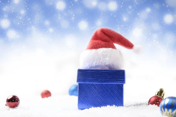 ギフト ボックス、サンタ帽子、抽象的な bac で雪中クリスマス ボール — ストック写真