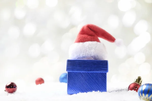 ギフト ボックス、サンタ帽子、抽象的な bac で雪中クリスマス ボール — ストック写真