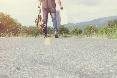 Genç adam Traveler açık yolda yürürken sırt çantası ile. 