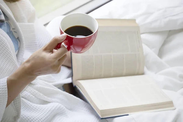 Conceito de relaxamento com bebida quente e leitura na cama  . — Fotografia de Stock