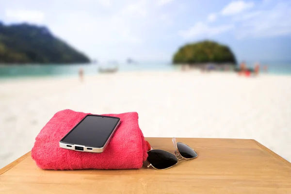 Red tower, sun glasses, mobile charging with power bank over woo — Stock Photo, Image