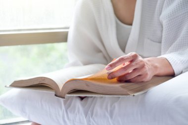 Kadın dinlenmek ve yatakta eski kitap okuma