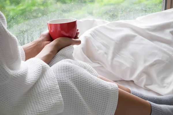 Relaksujące, młoda kobieta, ciesząc się jej kawę siedząc w łóżku. — Zdjęcie stockowe
