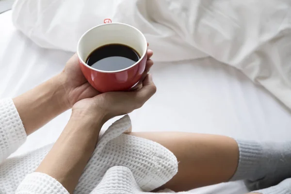 Relaxare femeie tânără se bucură de cafeaua ei în timp ce stau în pat . — Fotografie, imagine de stoc