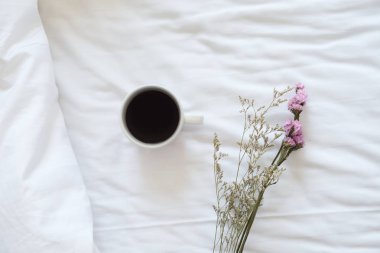 Kahve ve çiçek yatakta.