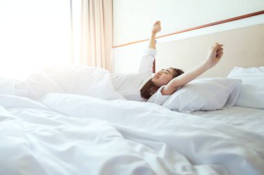 Güneş ışığı, sabah uyanma sonra yatakta uzanan kadın.