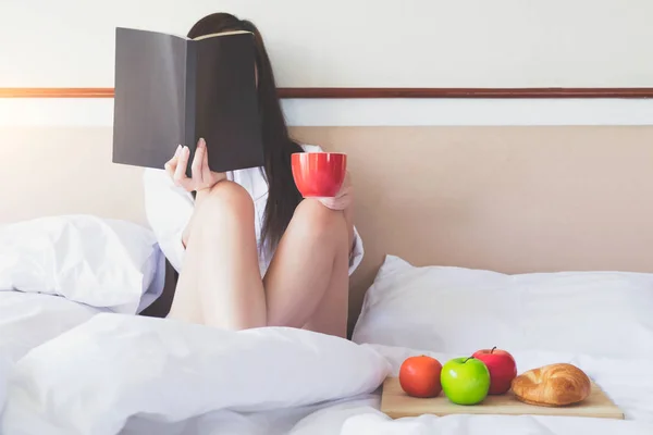 Relaxamento pela manhã lendo um livro e tomando café da manhã . — Fotografia de Stock