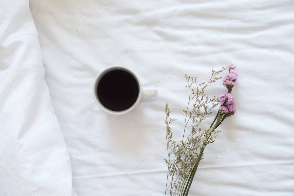 Coffee and flower in bed.