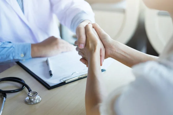 Male doctor in white coat shaking hand to female colleague — Stock Photo, Image