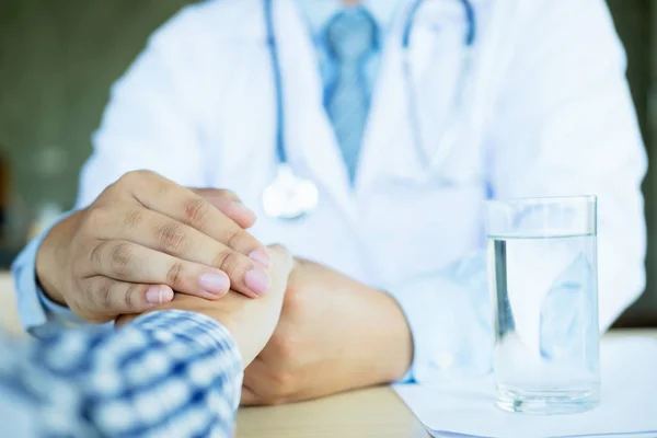 Hand van de dokter die zijn patiënt geruststelt — Stockfoto