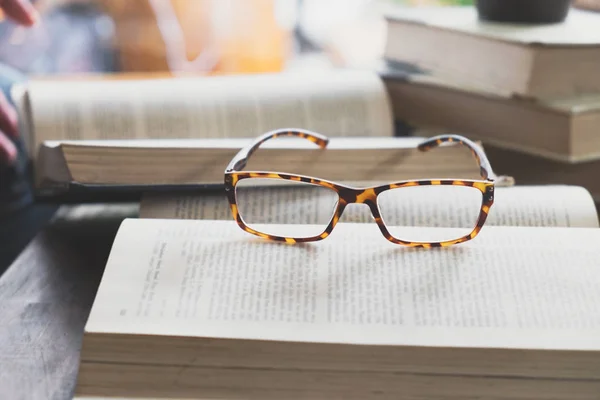 Brille beim Öffnen eines Buches in der Bibliothek oder im Café — Stockfoto