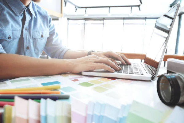 Fotografo creativo selezionare le immagini e utilizzando il computer per lavorare — Foto Stock