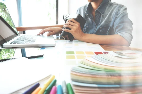 Fotografo creativo selezionare le immagini e utilizzando il computer per lavorare — Foto Stock