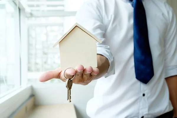 Hand agent with home in palm and key on finger. — Stock Photo, Image