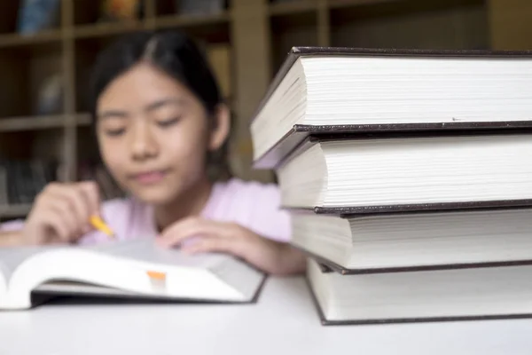 Onderwijs concept. Meisje lezen en schrijven in de bibliotheek van de school — Stockfoto