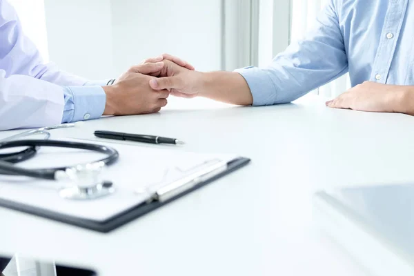 Hand van de dokter die zijn patiënt geruststelt — Stockfoto