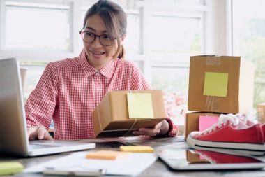 Müşteri siparişlerini denetleme için bilgisayar kullanarak çevrimiçi satıcı sahibi.