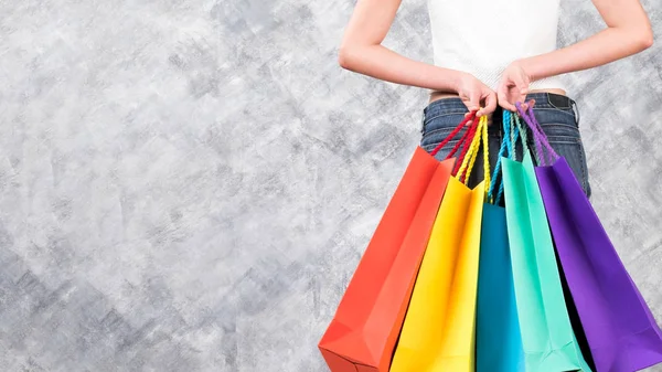 Bolsas de compras coloridas y mano de mujer en el espacio de copia de fondo —  Fotos de Stock