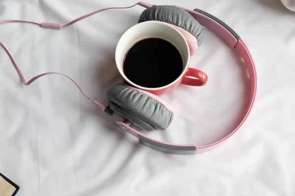 Pink handphone and red cup of coffee on bed in the morning. — Stock Photo, Image