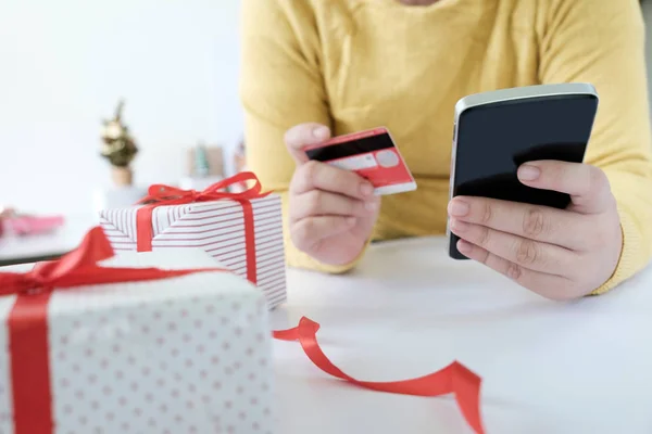Kvinde holder kreditkort og gør shopping online . Stock-billede