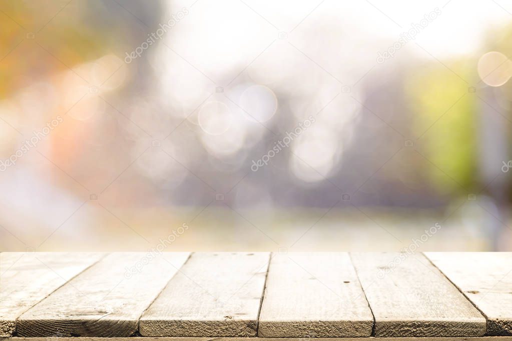 Wood table top on bokeh abstract background.