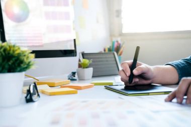 Masa başında çalışmak için grafik tableti kullanarak grafik tasarımcı
