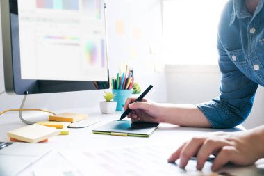 Masa başında çalışmak için grafik tableti kullanarak grafik tasarımcı