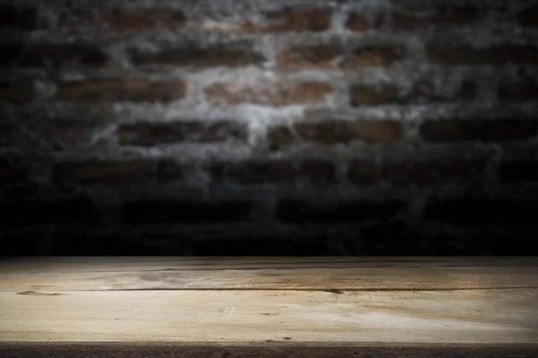 Τραπέζι από ξύλο πάνω σε παλιά φόντο σκοτεινό τούβλο τοίχο. — Φωτογραφία Αρχείου