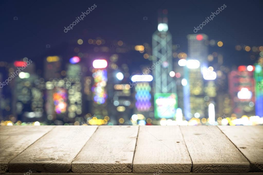 Wooden table with blur background of cityscape.