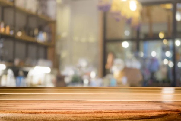 Mesa de madeira com fundo borrão de café — Fotografia de Stock