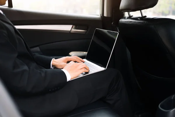 Geschäftsmann mit Computer arbeitendem Auto im Inneren — Stockfoto