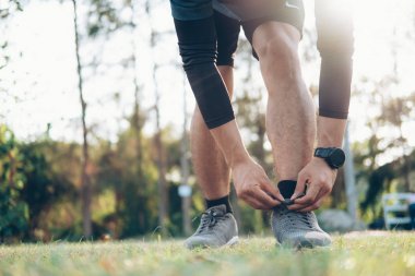 genç adam atlet ayakkabı bağcığı bağlama.