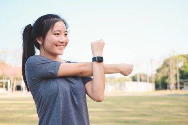 Genç bayan parkta esneme egzersizi yapıyor..