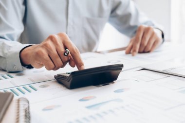 Erkek muhasebeci veya bankacı hesap makinesi kullanır.