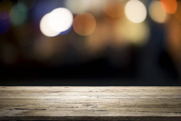 Lege houten tafel platform en bokeh nachts. — Stockfoto