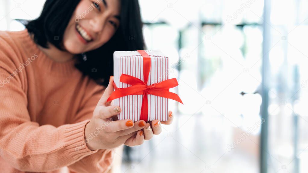 Closeup hands holding gift box of happy smiling young woman
