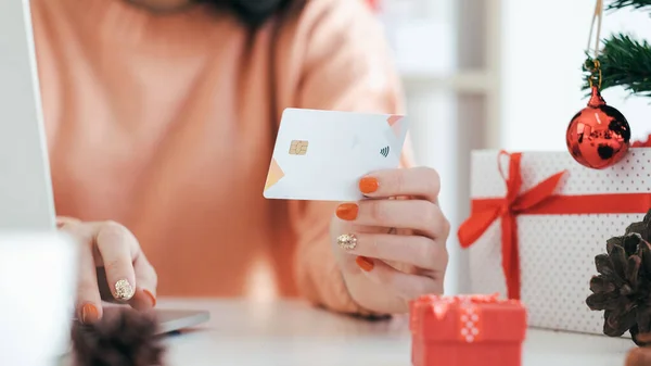Mujer joven sosteniendo tarjeta de crédito y haciendo compras en línea . — Foto de Stock