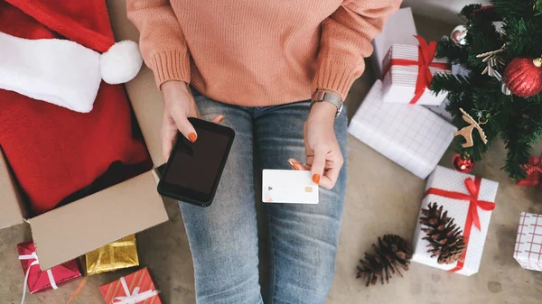 Mujer joven sosteniendo tarjeta de crédito y haciendo compras en línea . — Foto de Stock