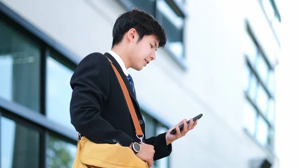 Fiatal üzletember használ mobiltelefon alkalmazás sms kívül Offic — Stock Fotó
