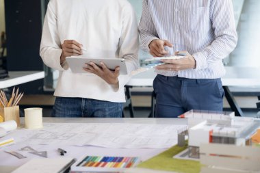 İş yerinde ortak ve mühendislik araçlarıyla çalışan mimari proje için mühendis toplantısı resmi.
