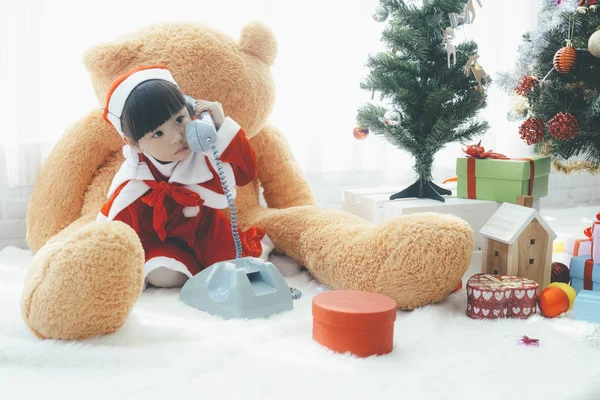 Menina brincando de brinquedo. Árvore de Natal no fundo . — Fotografia de Stock