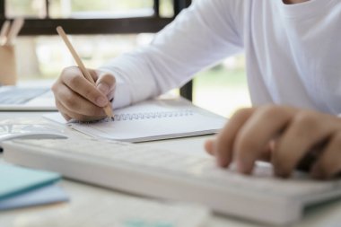 Deftere kalem yazarak ellerinizi kapatın. Eğitim kavramı.