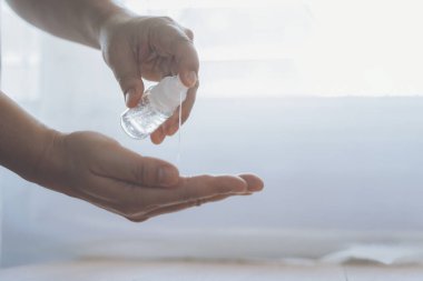 COVID-19, Novel Coronavirus 'a (2019-nCoV) karşı antibakteriyel yıkama jel dezenfektanı kullanan adamı kapatın. Ev izolasyonu ve sağlık hizmeti kavramı.